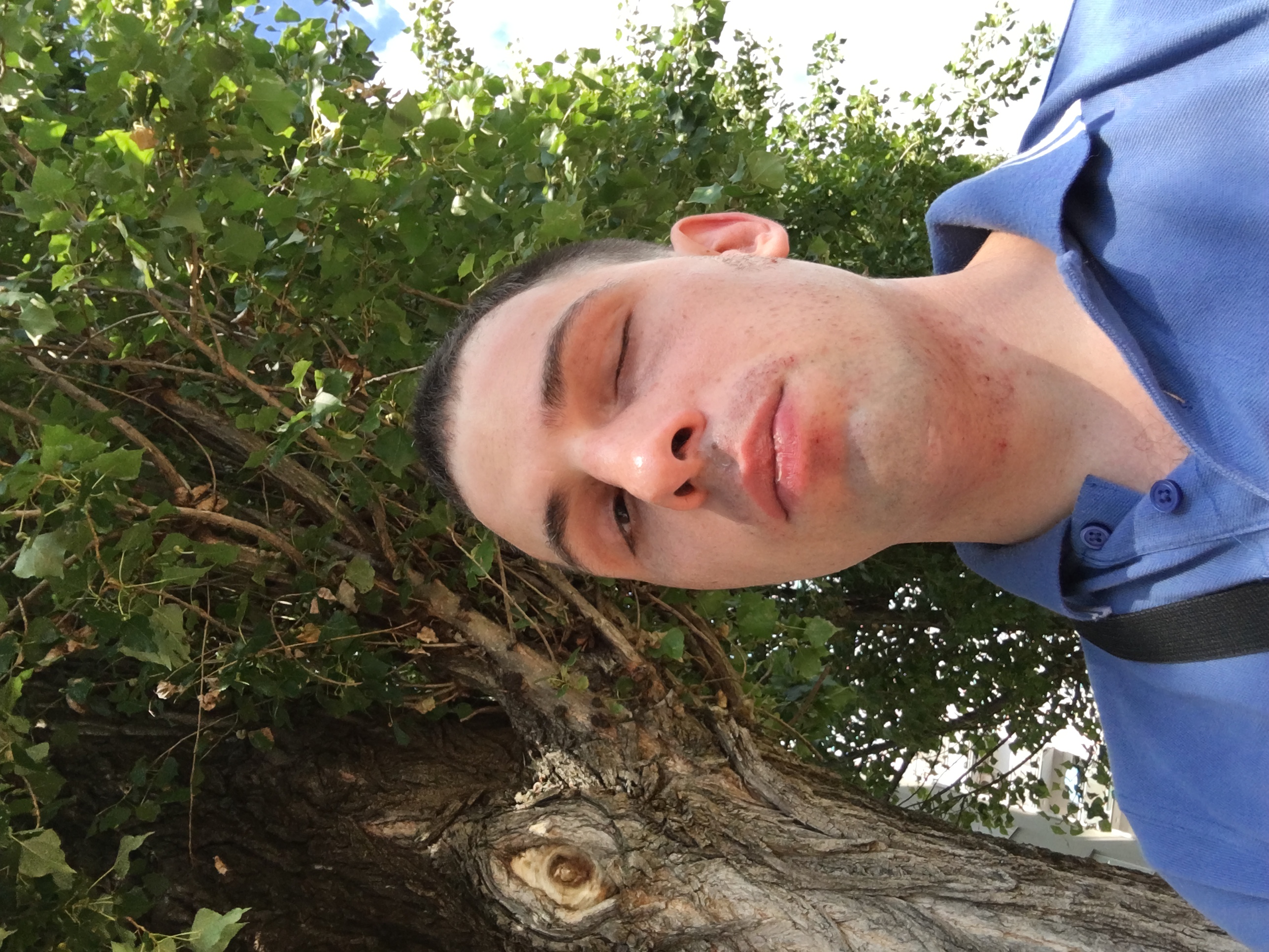 Hrvoje Katić nasmijan na suncu kraj stabla, nosi plavu polo majicu